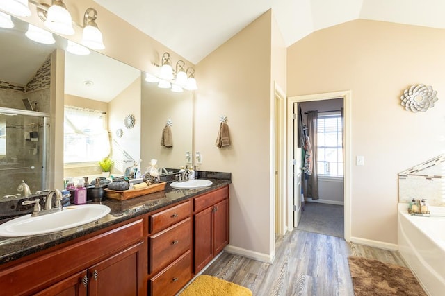 bathroom featuring lofted ceiling, independent shower and bath, hardwood / wood-style floors, and vanity