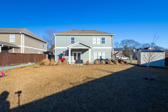 rear view of property featuring a storage unit