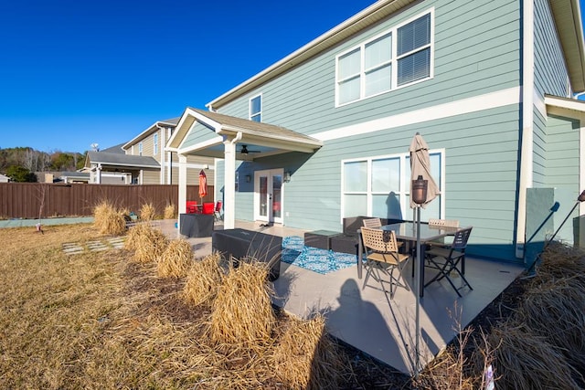 back of house with an outdoor living space and a patio area