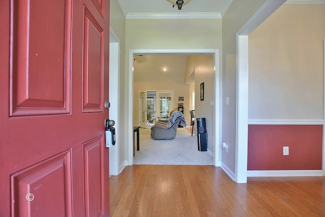 entryway featuring ornamental molding, light wood-style floors, and baseboards