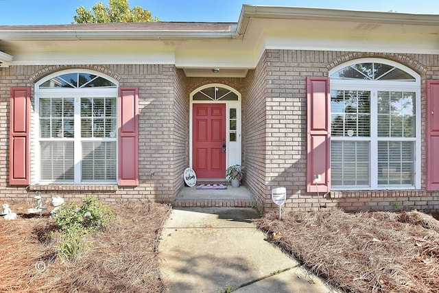 entrance to property featuring brick siding