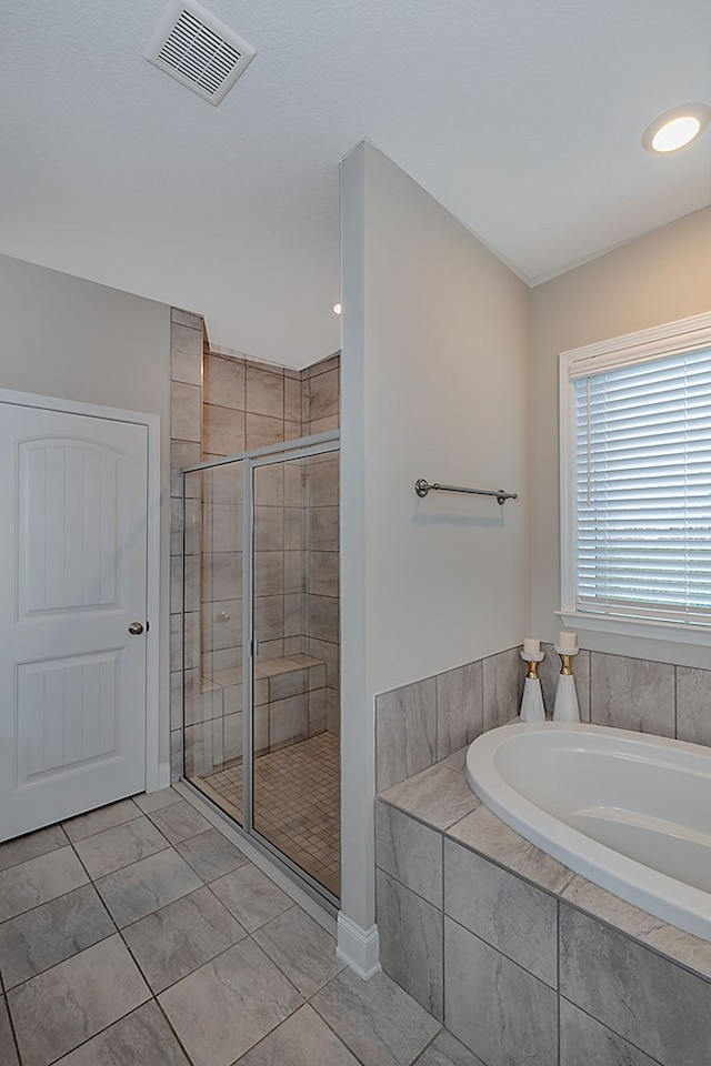 bathroom featuring plus walk in shower and tile patterned flooring