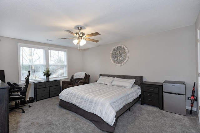 carpeted bedroom featuring ceiling fan and refrigerator