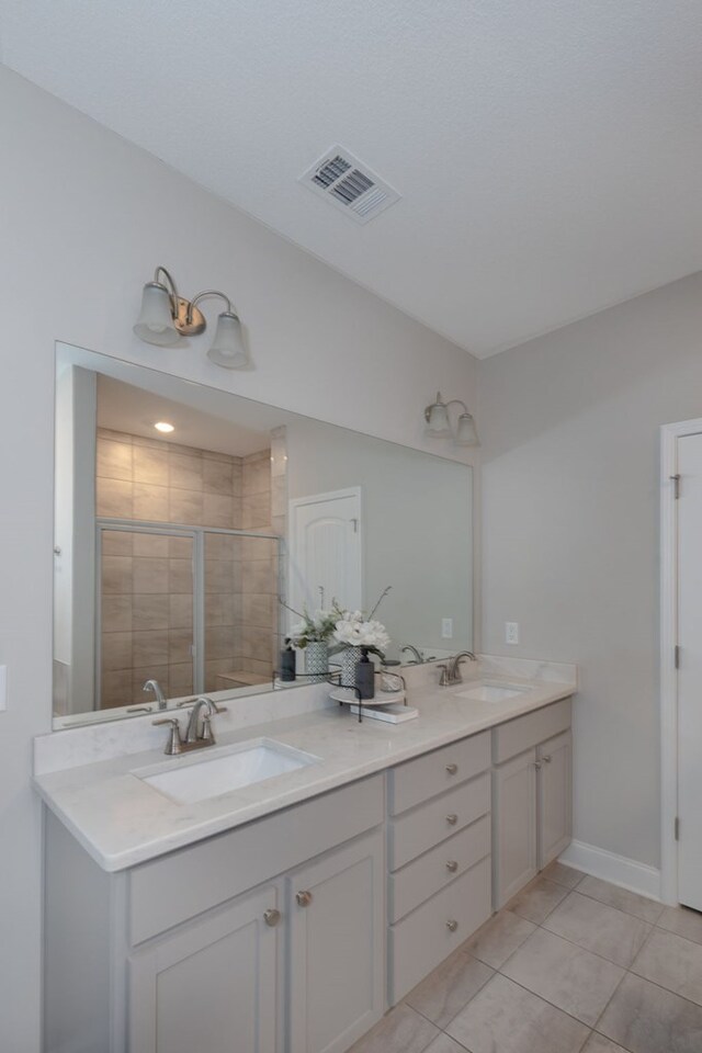 bathroom with vanity, tile patterned floors, and a shower with door