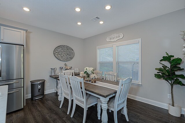 dining room with a textured ceiling and dark hardwood / wood-style floors