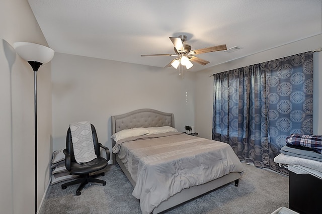 carpeted bedroom with ceiling fan and a textured ceiling