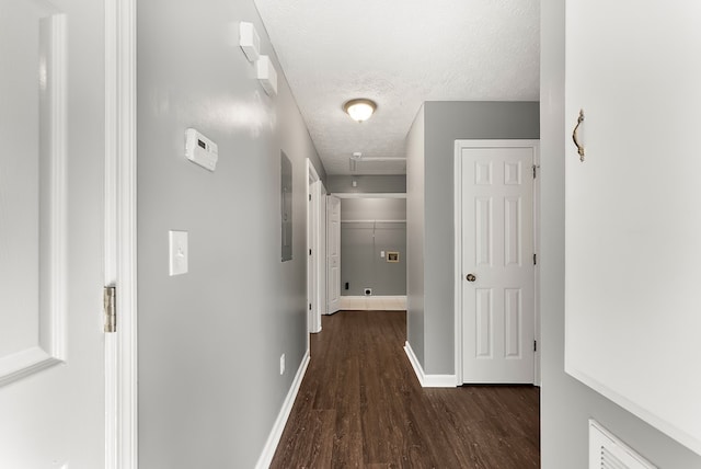 corridor with dark wood-type flooring and a textured ceiling