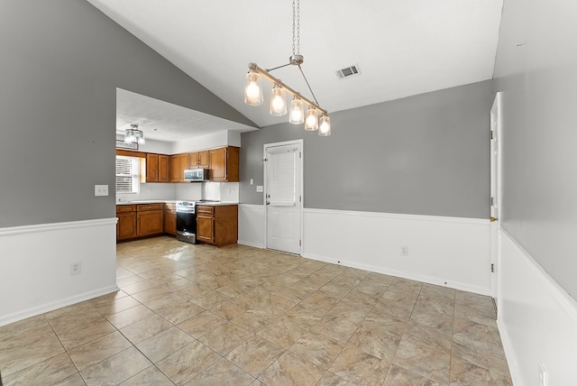 kitchen featuring appliances with stainless steel finishes, decorative light fixtures, and vaulted ceiling