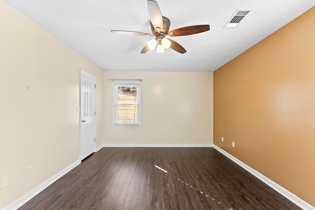 spare room with a textured ceiling, dark wood-type flooring, and ceiling fan