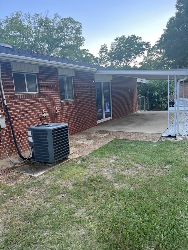 4229 Empire St, Columbus, GA 31907 - back of house with brick siding, a carport, a patio area, and a lawn