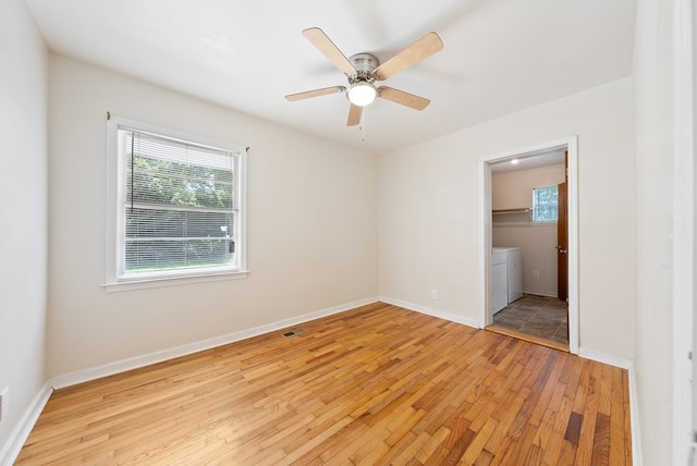 unfurnished bedroom featuring light wood-type flooring, washer / dryer, baseboards, and a ceiling fan