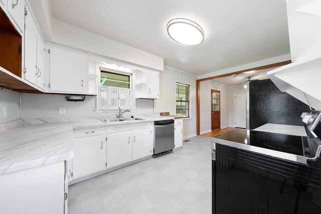 kitchen with a sink, light flooring, light countertops, white cabinets, and dishwasher