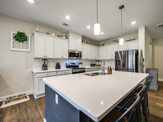 13733 Macon Rd, Upatoi, GA 31829 - kitchen with stainless steel appliances, dark wood-style floors, decorative backsplash, a center island with sink, and recessed lighting