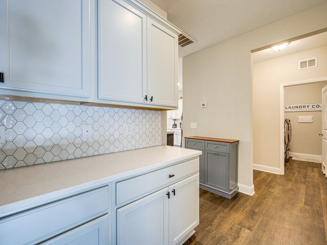 13733 Macon Rd, Upatoi, GA 31829 - kitchen featuring dark wood finished floors, backsplash, light countertops, and washer / dryer