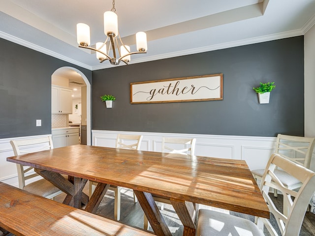 13733 Macon Rd, Upatoi, GA 31829 - dining room with a tray ceiling, a chandelier, a decorative wall, crown molding, and arched walkways