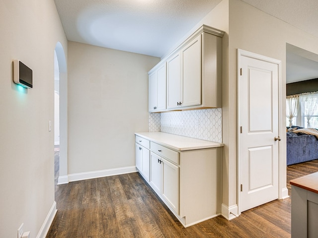 13733 Macon Rd, Upatoi, GA 31829 - bar area with dark wood-type flooring, decorative backsplash, and arched walkways