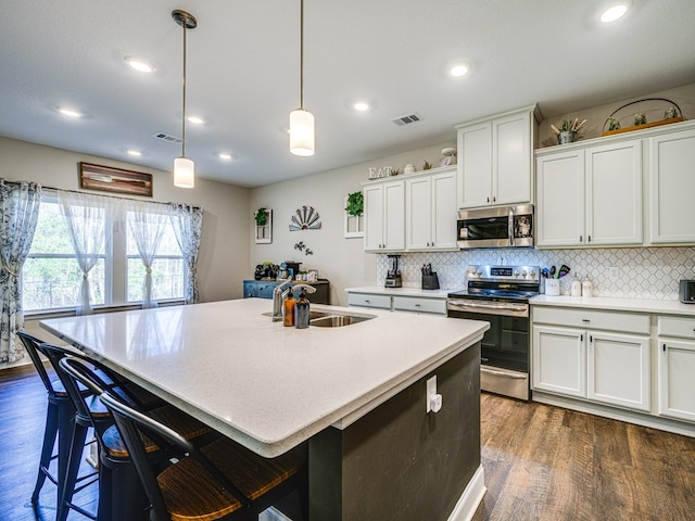 13733 Macon Rd, Upatoi, GA 31829 - kitchen featuring appliances with stainless steel finishes, dark wood-style flooring, decorative backsplash, light countertops, and recessed lighting