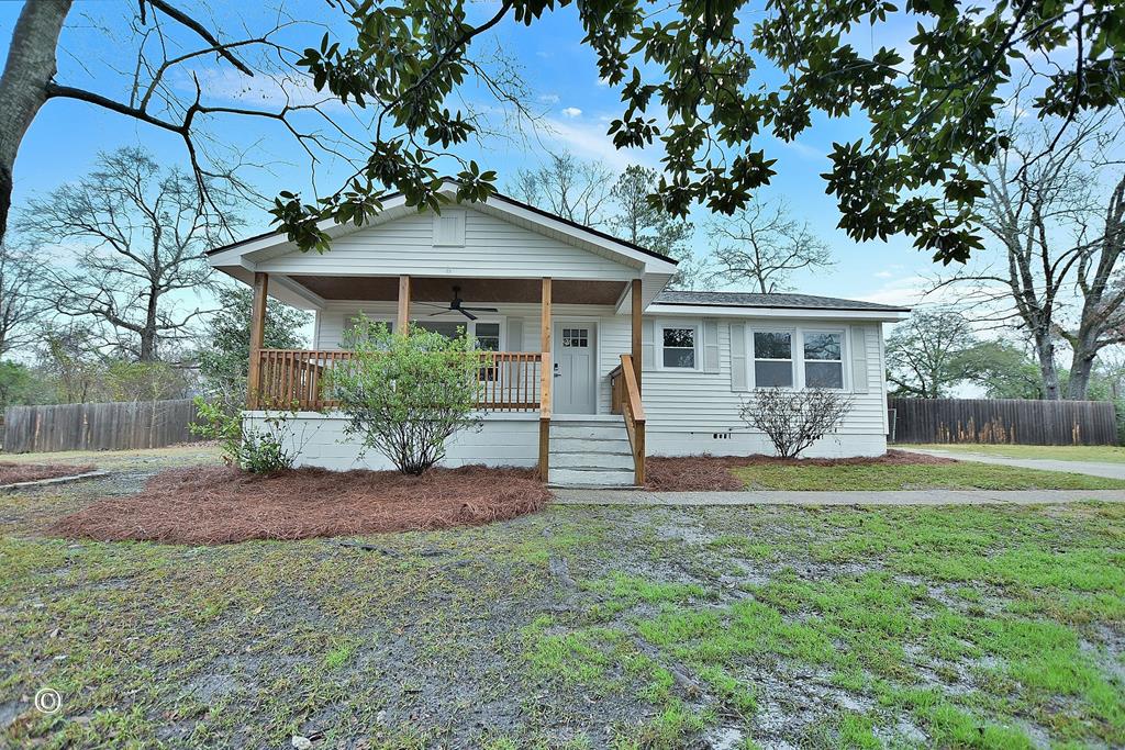 view of front of property featuring covered porch, ceiling fan, and a front yard