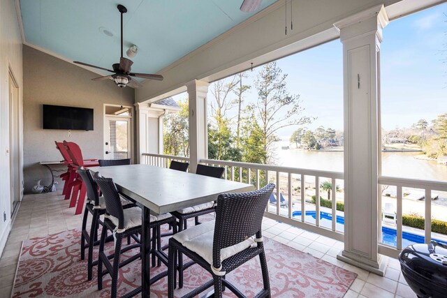 exterior space with a ceiling fan, a water view, ornate columns, and a healthy amount of sunlight