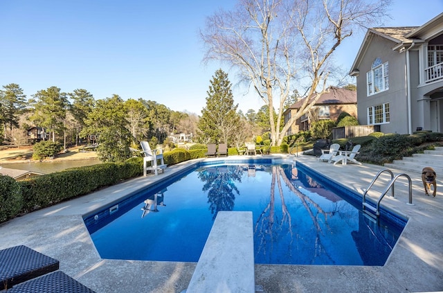 pool featuring a patio area and a diving board