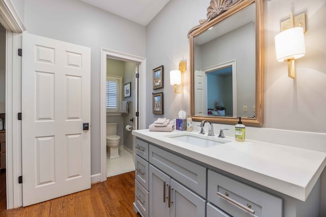 bathroom featuring toilet, wood finished floors, and vanity