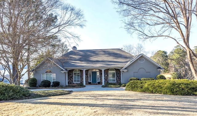 view of front of home featuring stucco siding, stone siding, and a chimney