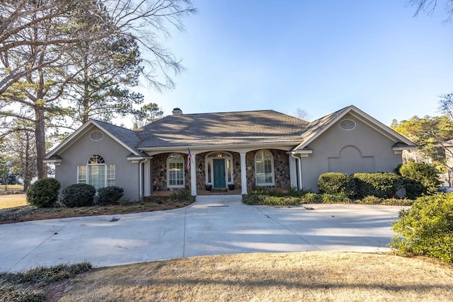 ranch-style home featuring driveway, covered porch, a chimney, stucco siding, and stone siding