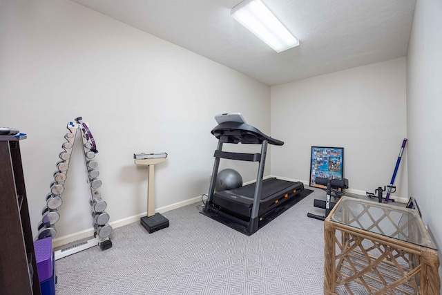 workout room featuring baseboards and carpet