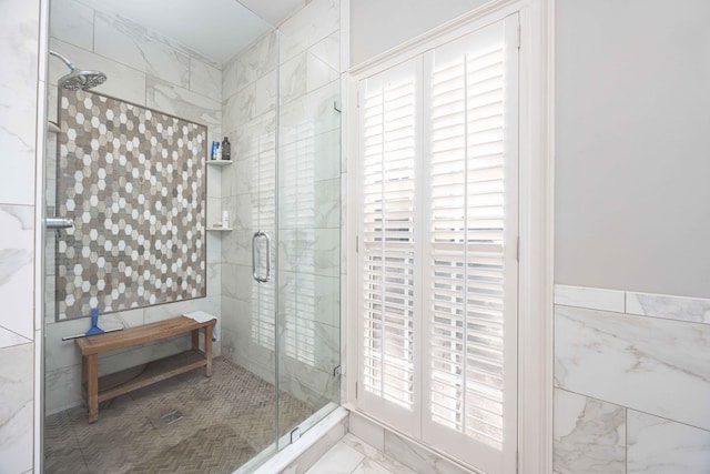 full bath with tile walls, marble finish floor, and a shower stall