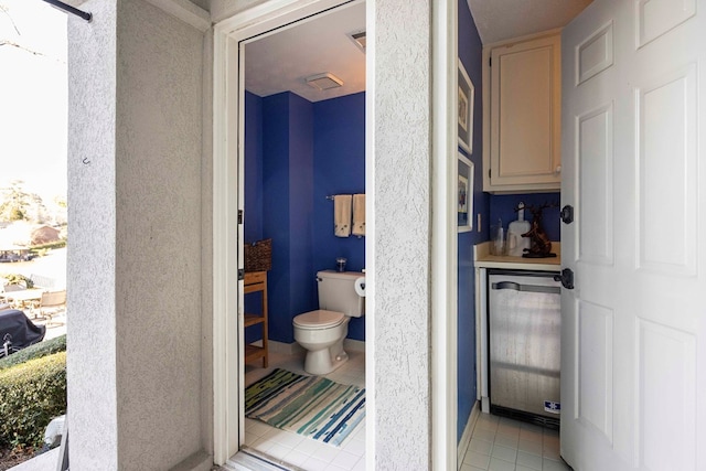 bathroom with tile patterned floors, visible vents, and toilet