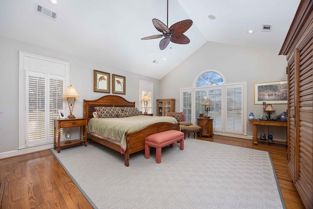 bedroom featuring visible vents, high vaulted ceiling, wood finished floors, and a ceiling fan