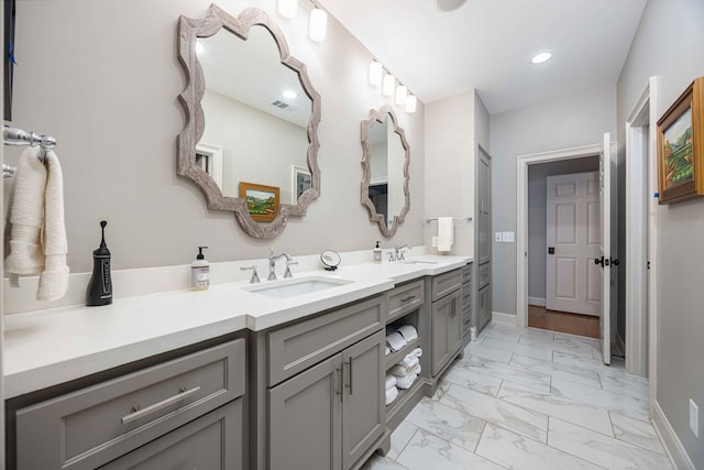 full bath featuring double vanity, visible vents, marble finish floor, and a sink