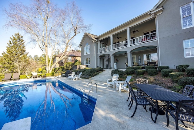 outdoor pool featuring stairs, outdoor dining space, a ceiling fan, and a patio area