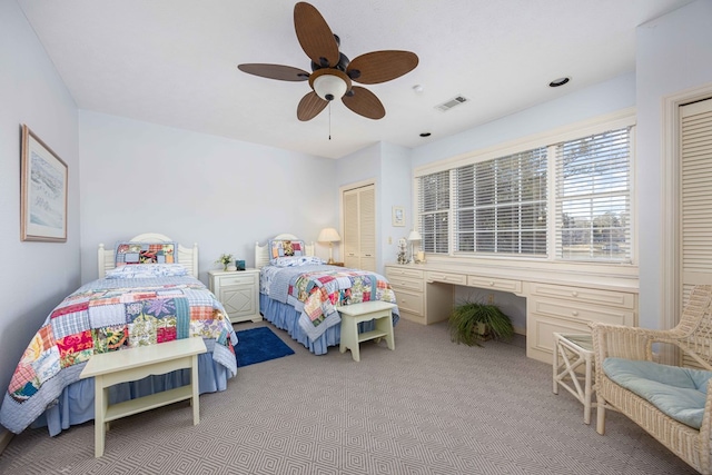 bedroom featuring built in desk, a ceiling fan, carpet, and visible vents