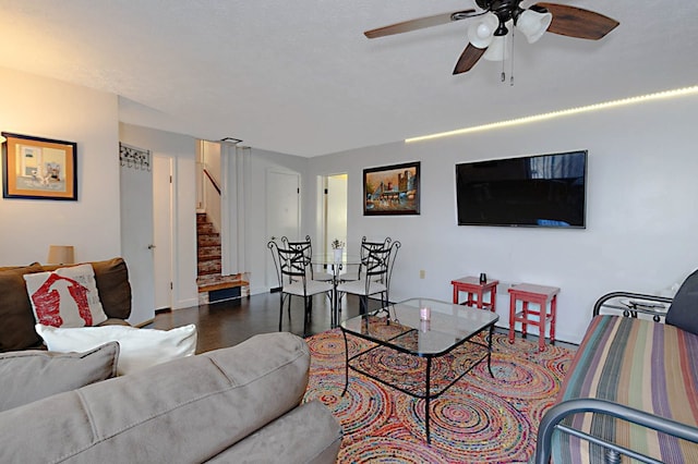 living area featuring stairway, ceiling fan, wood finished floors, and baseboards