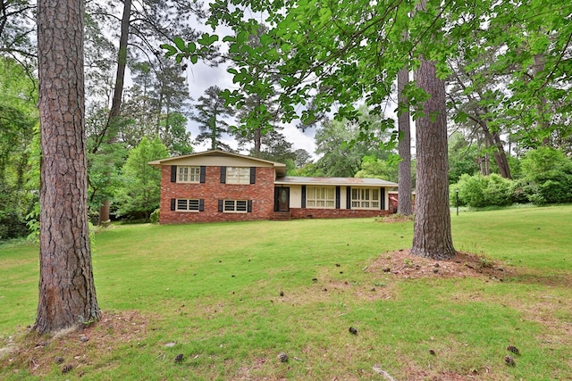 tri-level home featuring brick siding and a front lawn