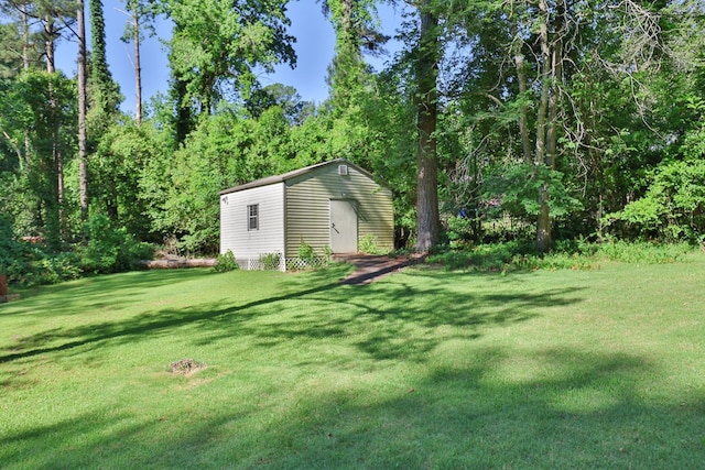 view of grassy yard with an outbuilding and a storage shed