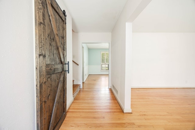 2951 Florence Dr, Columbus, GA 31907 - hall with a barn door, light wood-style floors, baseboards, and stairs