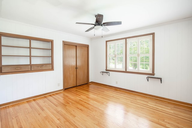 2951 Florence Dr, Columbus, GA 31907 - unfurnished bedroom with light wood-type flooring, baseboards, crown molding, wood walls, and ceiling fan