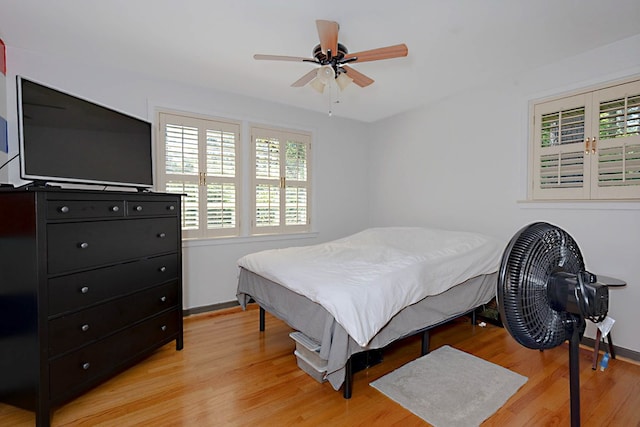 bedroom featuring light wood-type flooring, baseboards, and a ceiling fan