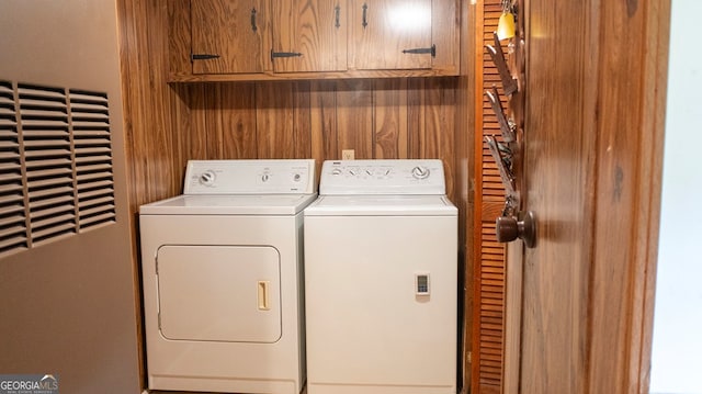 laundry room featuring cabinets and washer and clothes dryer