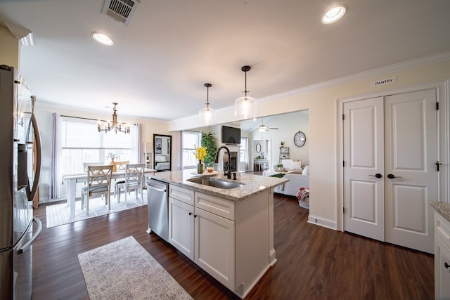 kitchen featuring sink, a kitchen island with sink, white cabinetry, stainless steel appliances, and decorative light fixtures