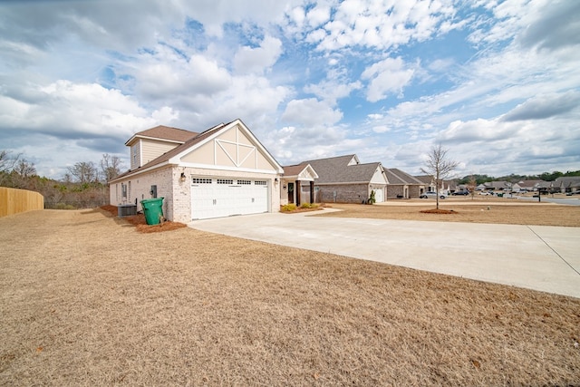 view of front of house featuring a garage, a front yard, and central air condition unit