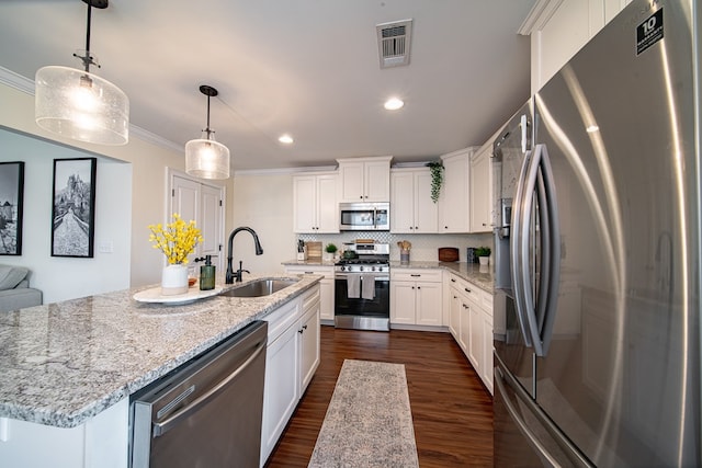 kitchen featuring sink, decorative light fixtures, stainless steel appliances, a kitchen island with sink, and white cabinets