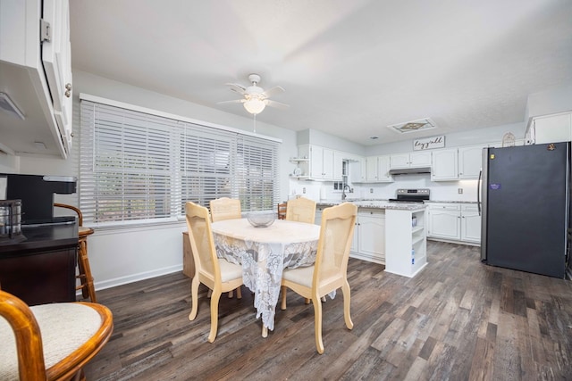 dining area with sink, ceiling fan, and dark wood-type flooring