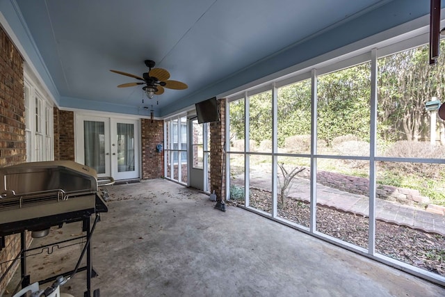 unfurnished sunroom featuring ceiling fan