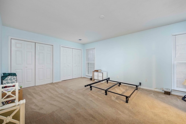 carpeted bedroom with multiple closets