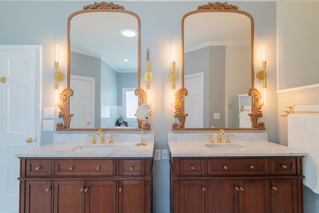 full bath with crown molding, two vanities, and a sink