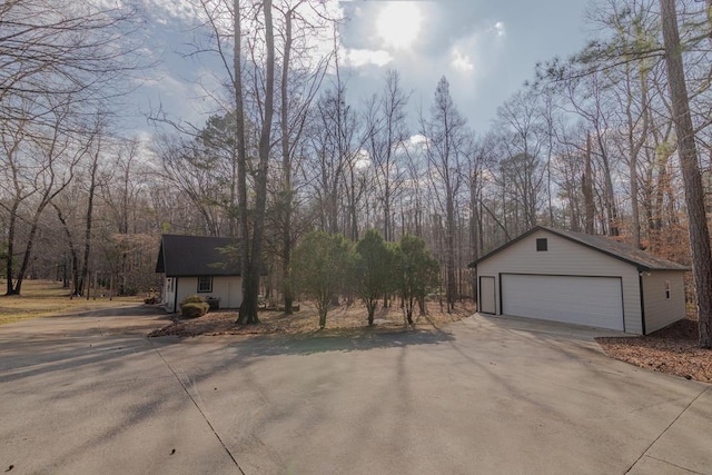 view of property exterior featuring a detached garage and an outdoor structure