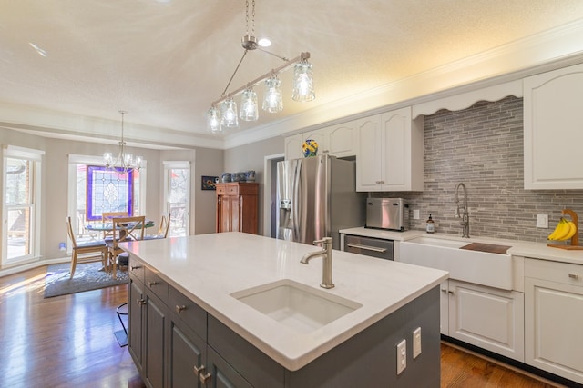 kitchen with a sink, white cabinets, a healthy amount of sunlight, and stainless steel appliances